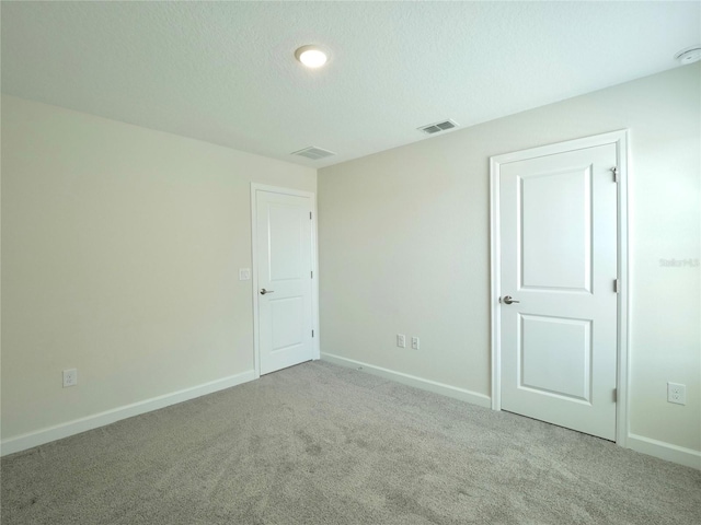 carpeted spare room with a textured ceiling