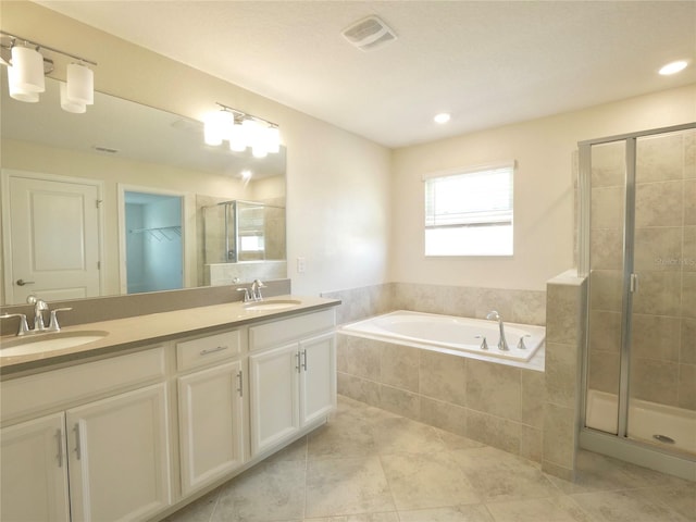 bathroom with tile patterned floors, vanity, and shower with separate bathtub