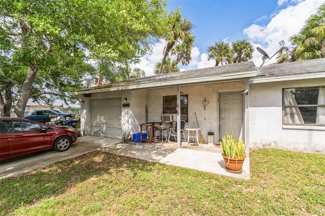 exterior space with cooling unit, a front yard, and a garage