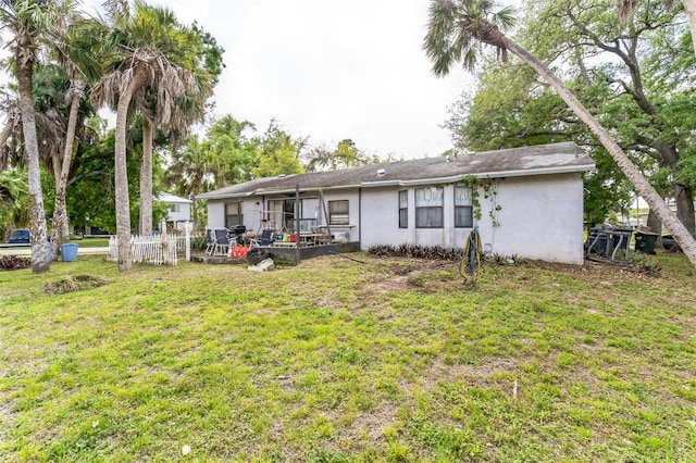 rear view of house featuring a lawn