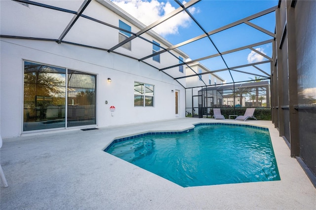 view of pool with glass enclosure and a patio