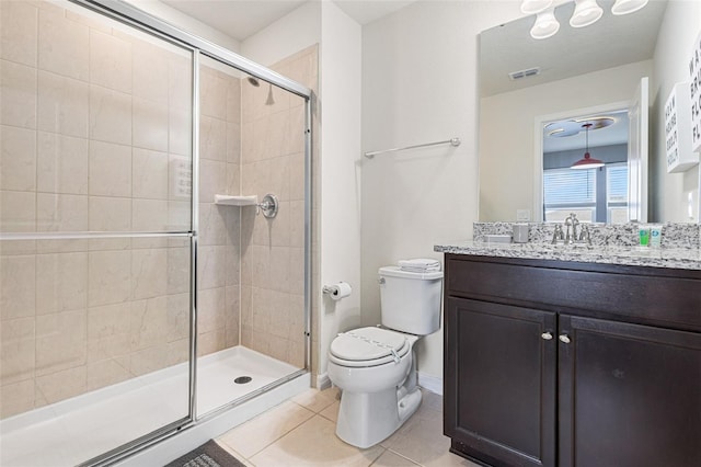 bathroom featuring tile patterned floors, vanity, a shower with shower door, and toilet