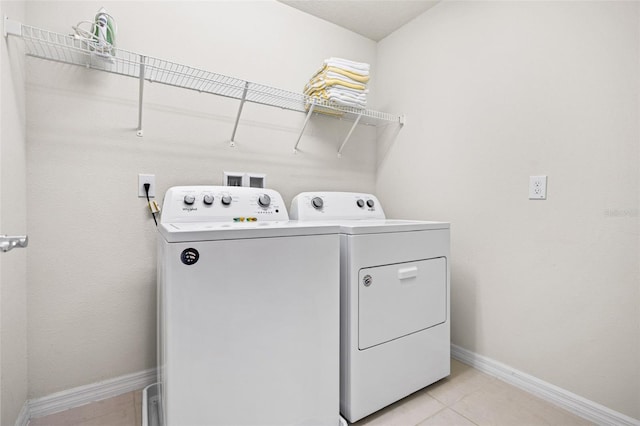 washroom featuring washer and clothes dryer and light tile patterned floors