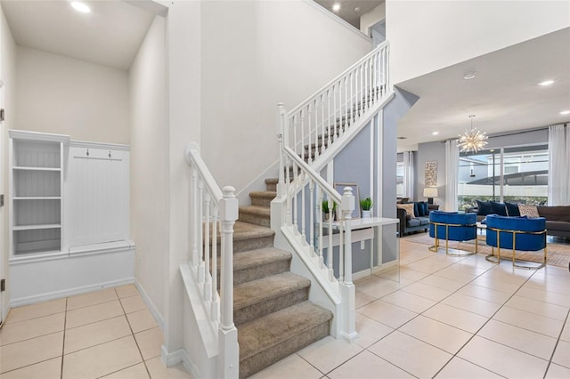 stairway with tile patterned flooring and a chandelier