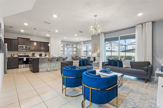 living room with light tile patterned flooring and an inviting chandelier