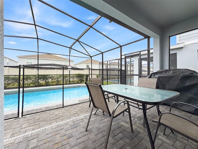 view of swimming pool with glass enclosure, a patio, and grilling area