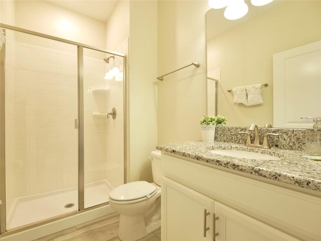 bathroom featuring hardwood / wood-style floors, vanity, toilet, and walk in shower