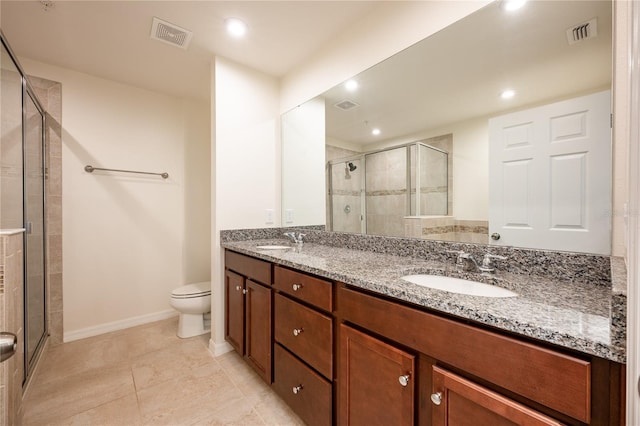 bathroom featuring tile patterned flooring, vanity, toilet, and a shower with door