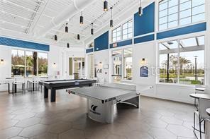 playroom with a towering ceiling and pool table