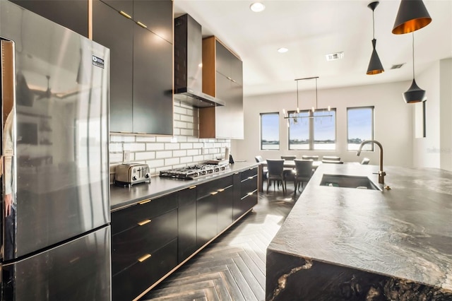 kitchen featuring sink, wall chimney exhaust hood, decorative backsplash, decorative light fixtures, and stainless steel appliances