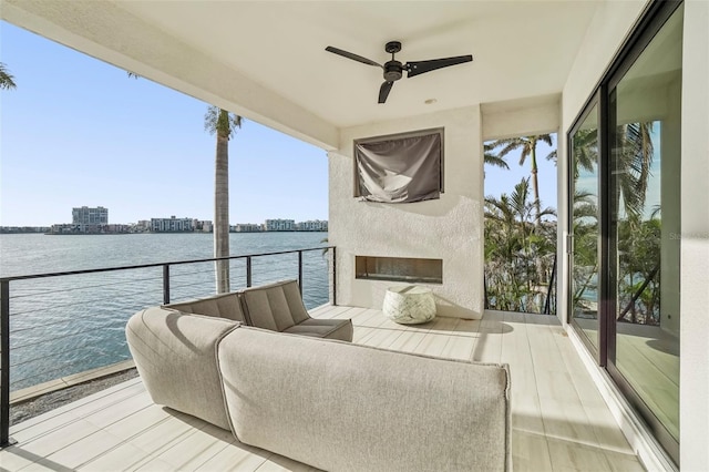 sunroom / solarium featuring ceiling fan and a water view