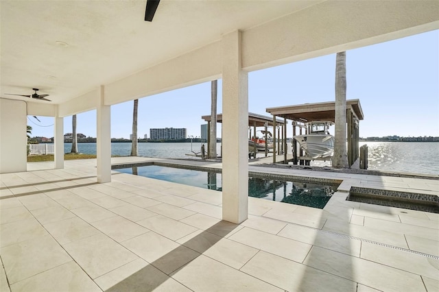 exterior space with ceiling fan, a patio area, a water view, and a dock