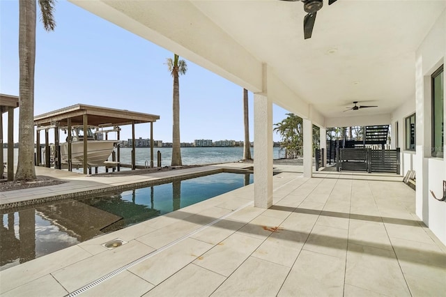 exterior space featuring a boat dock, ceiling fan, and a water view