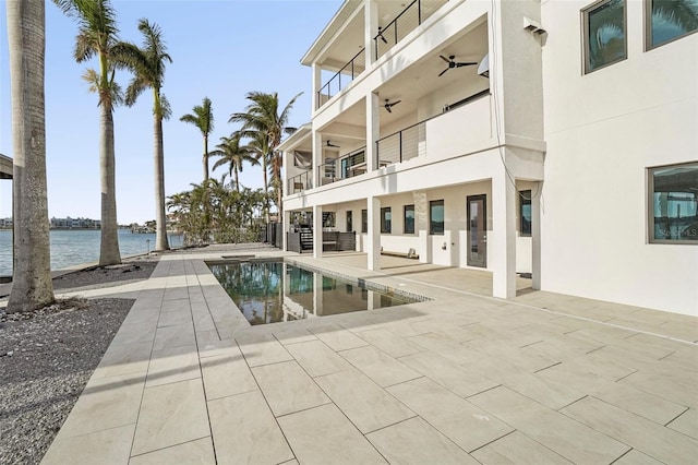 view of pool featuring a water view and a patio