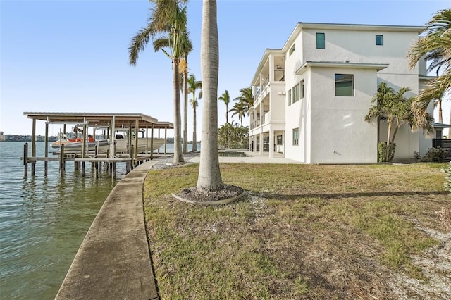 view of dock featuring a water view and a lawn