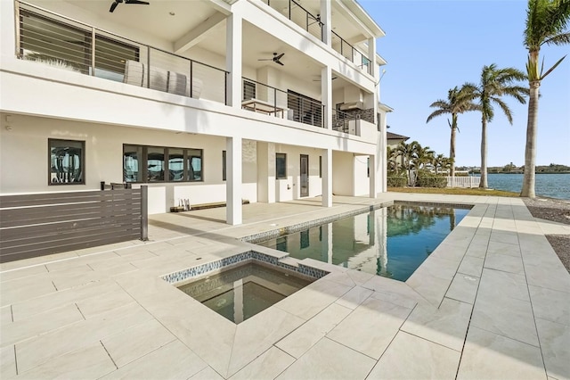 view of pool featuring ceiling fan, a water view, an in ground hot tub, and a patio