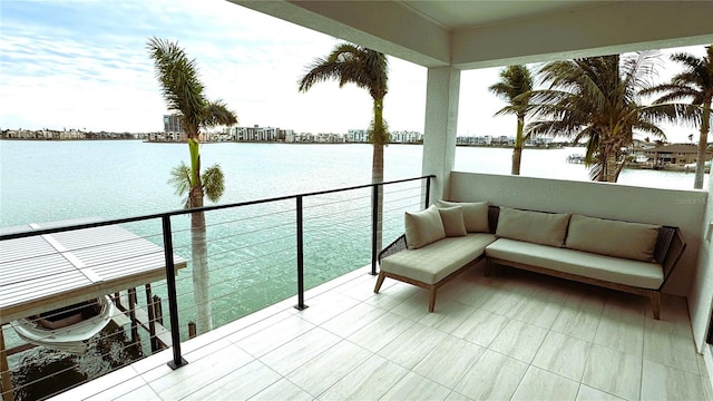 balcony featuring an outdoor living space and a water view