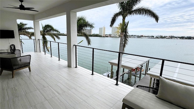 view of patio featuring ceiling fan, a water view, and a balcony