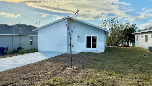 back of property featuring cooling unit and a lawn