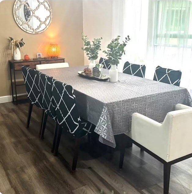 dining room with wood-type flooring and an inviting chandelier