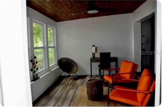 living area with ceiling fan, wood ceiling, and wood-type flooring