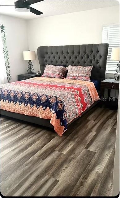 bedroom with ceiling fan and dark hardwood / wood-style flooring