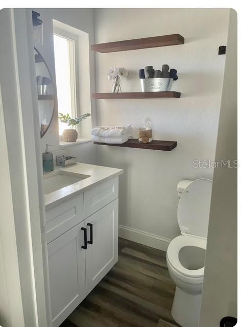 bathroom featuring vanity, hardwood / wood-style flooring, and toilet