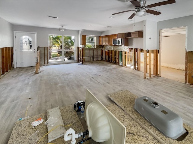 unfurnished living room with ceiling fan