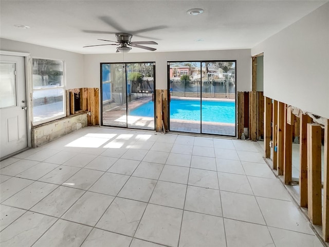 tiled empty room featuring ceiling fan