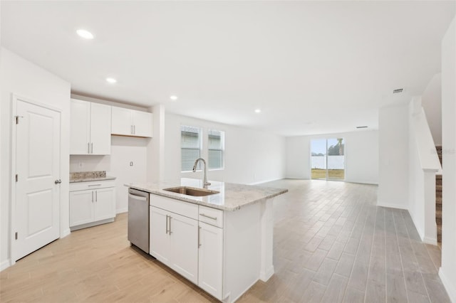 kitchen with sink, white cabinetry, dishwasher, a healthy amount of sunlight, and a kitchen island with sink