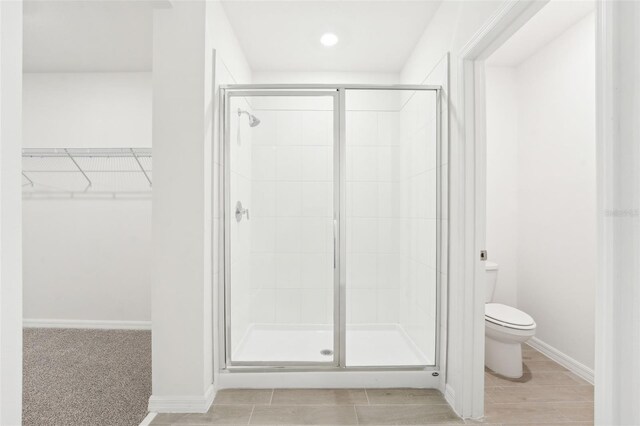 bathroom with walk in shower and toilet