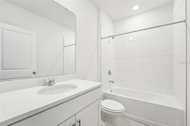 full bathroom with vanity, hardwood / wood-style floors, tiled shower / bath combo, and toilet