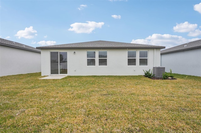 rear view of property featuring a yard and central AC unit