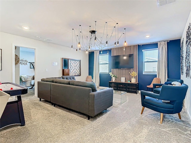 carpeted living room with a notable chandelier and a healthy amount of sunlight