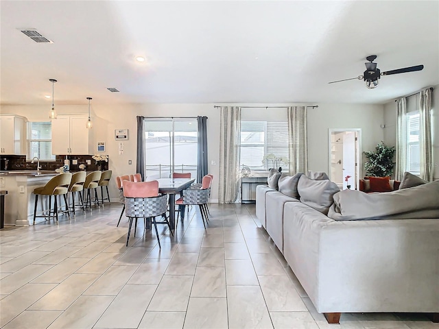 tiled living room featuring ceiling fan