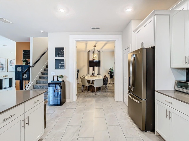 kitchen featuring white cabinetry, stainless steel fridge with ice dispenser, and light tile patterned flooring