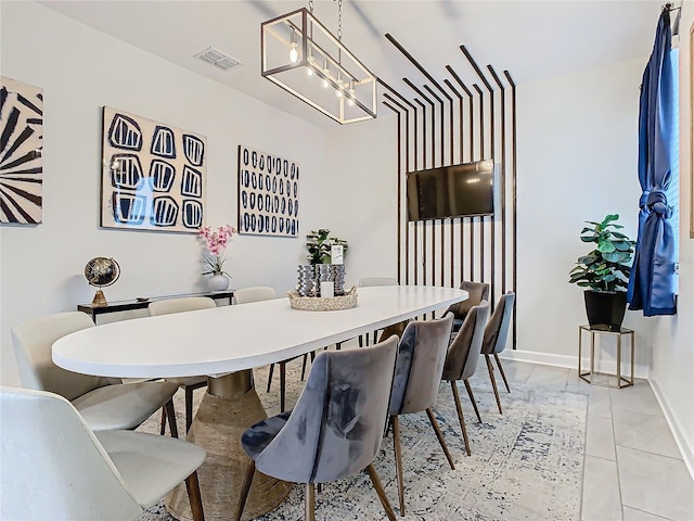 tiled dining space with a chandelier