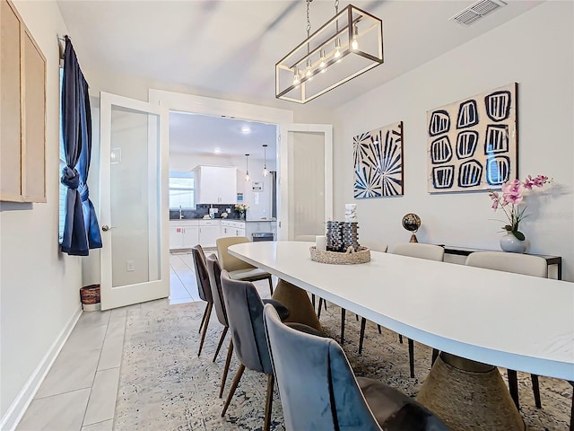 dining space with light tile patterned floors and a chandelier