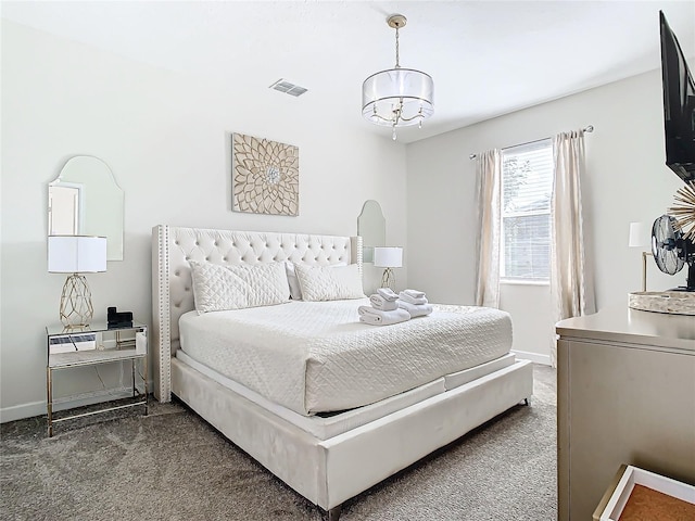 carpeted bedroom featuring an inviting chandelier