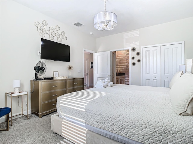 bedroom featuring an inviting chandelier, a closet, and light colored carpet