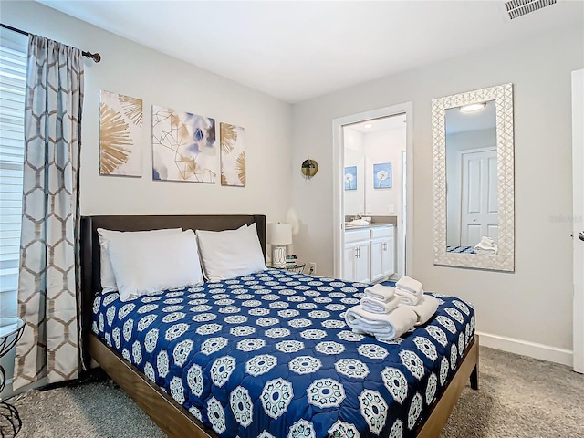 bedroom featuring ensuite bathroom and carpet floors