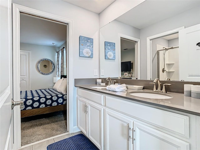 bathroom with a shower with shower door, tile patterned floors, and vanity