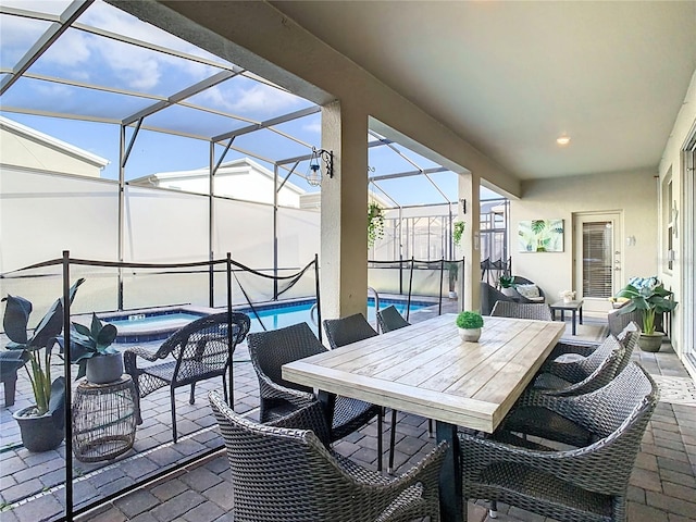 view of patio / terrace featuring glass enclosure and a swimming pool with hot tub