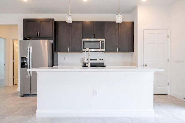 kitchen featuring dark brown cabinetry, a kitchen island with sink, pendant lighting, and stainless steel appliances