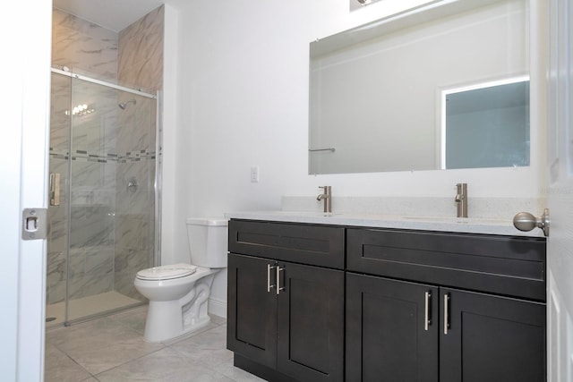 bathroom featuring tile patterned flooring, vanity, a shower with shower door, and toilet