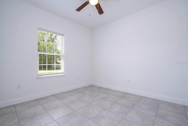 tiled spare room with ceiling fan