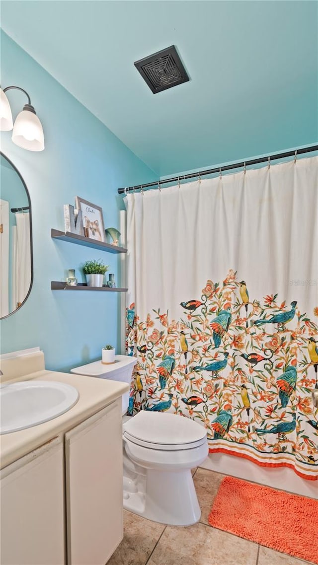 bathroom with tile patterned flooring, vanity, and toilet