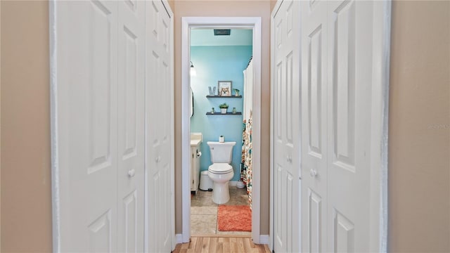 bathroom with wood-type flooring and toilet