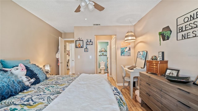 bedroom featuring hardwood / wood-style flooring, ceiling fan, a textured ceiling, and ensuite bath