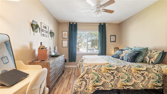 bedroom featuring ceiling fan, light hardwood / wood-style flooring, and a textured ceiling